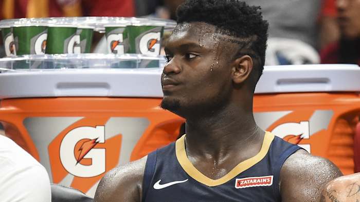 Zion Williamson sits on the Pelicans bench during preseason.